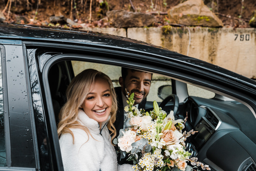 A bride and groom in their car ready to head to their wedding ceremony