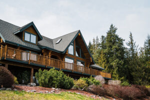 a large log cabin surrounded by forest