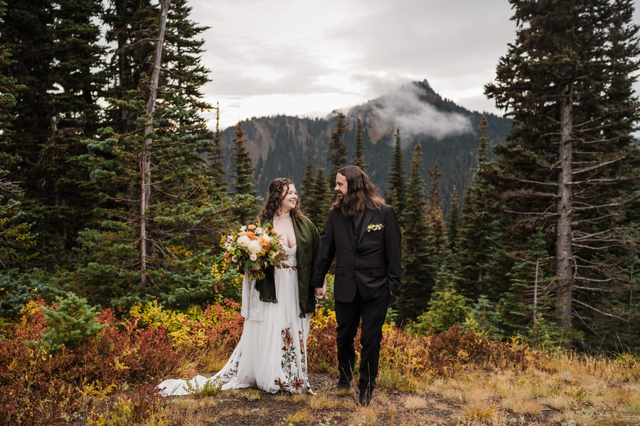 a couple walks through a field of fall colors on hurricane ridge during their olympic national park elopement