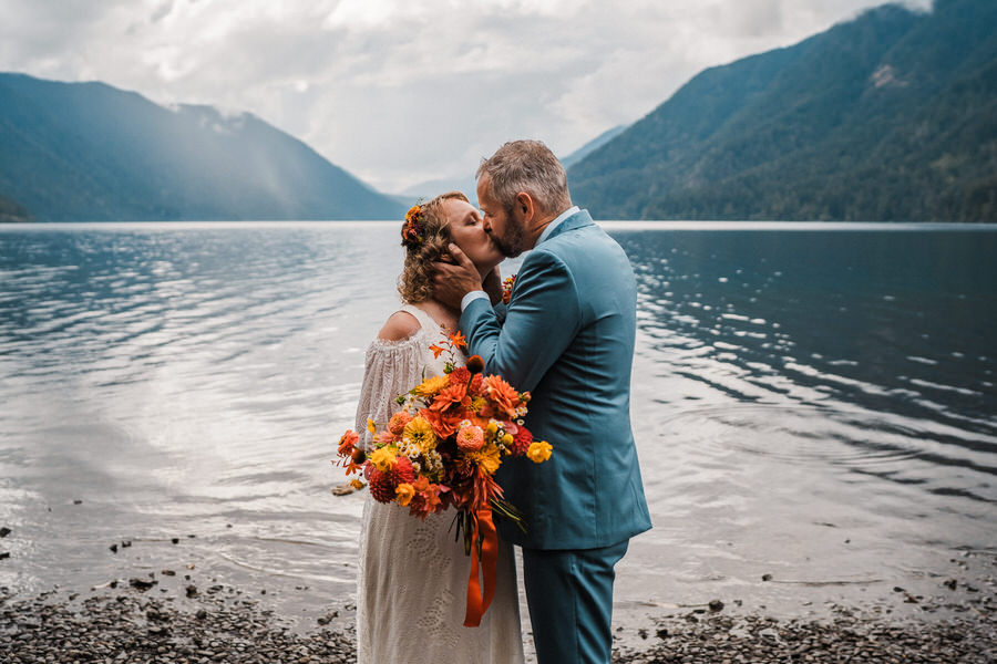 a bride and groom kiss along the shores of lake crescent on their olympic national park elopement day